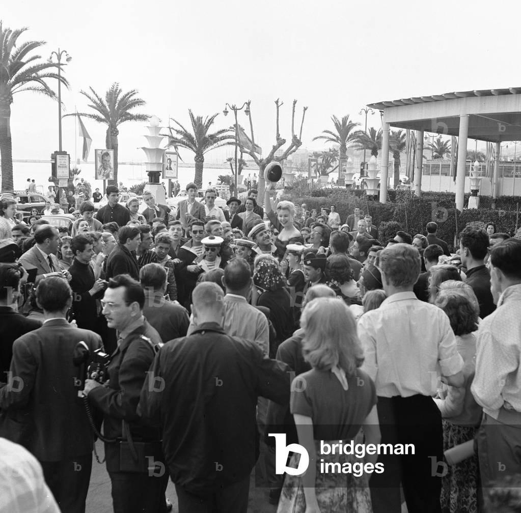 Mitzi Gaynor, American actress, singer & dancer receives help from French sailors as she is besieged by fans at 1958 Cannes Film Festival in France May 1958 (b/w photo)