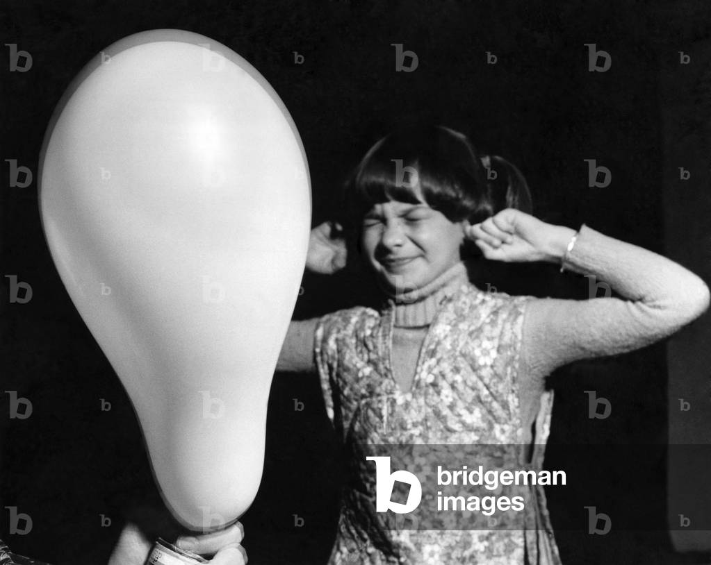 Little Tamara Hallett grits her teeth for the moment that every child dreads. A balloon has been blown up too far and it bursts as pricked by a pin, 22nd October 1976