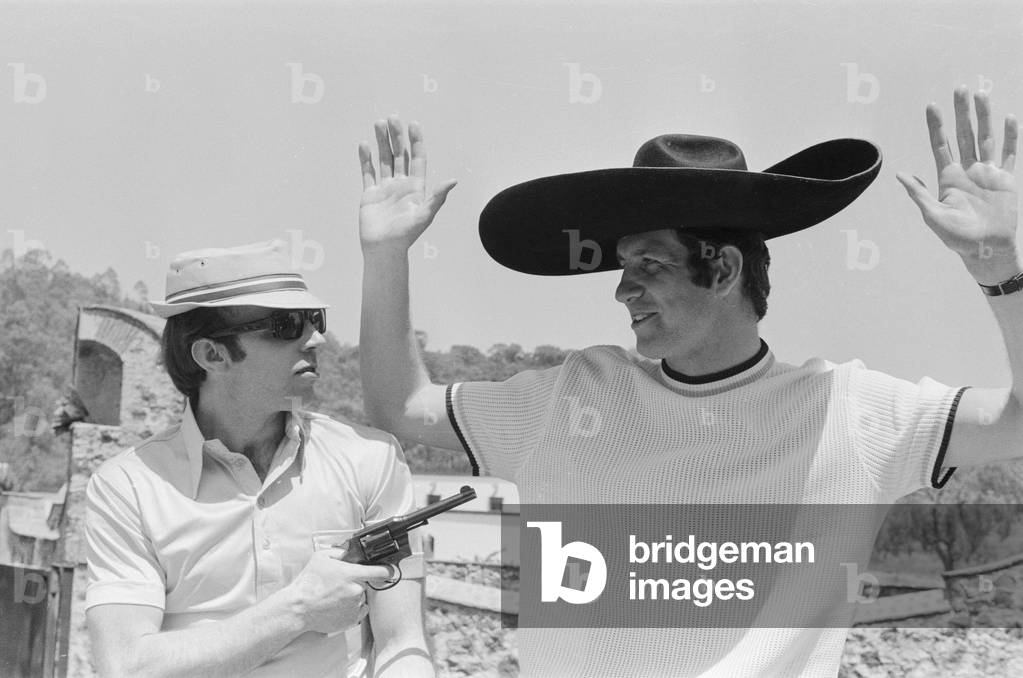 1970 World Cup Finals in Mexico. England's Nobby Stiles holding up a teammate with a pistol at the Rodeo in the old Olympic village, 11th May 1970 (b/w photo)
