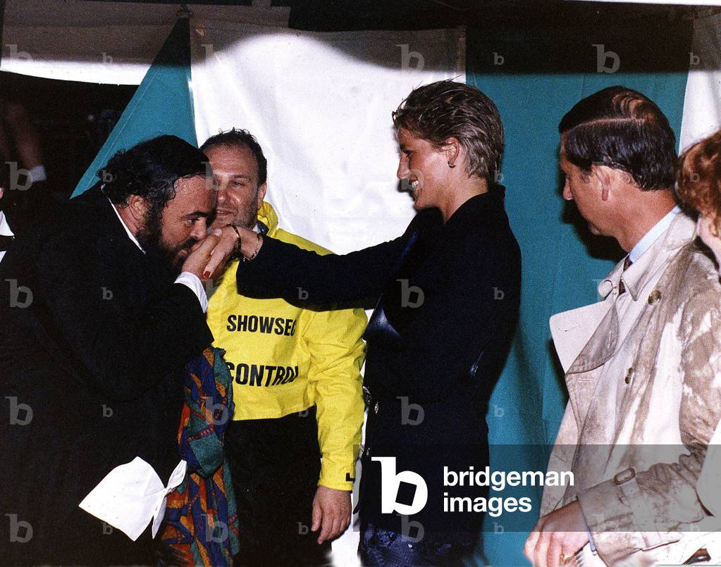 Luciano Pavarotti Opera Singer kisses the hand of Princess Diana as Prince Charles looks on after the rain soaked Pavarotti in the Park concert in Hyde Park in London, July 1991 (photo)