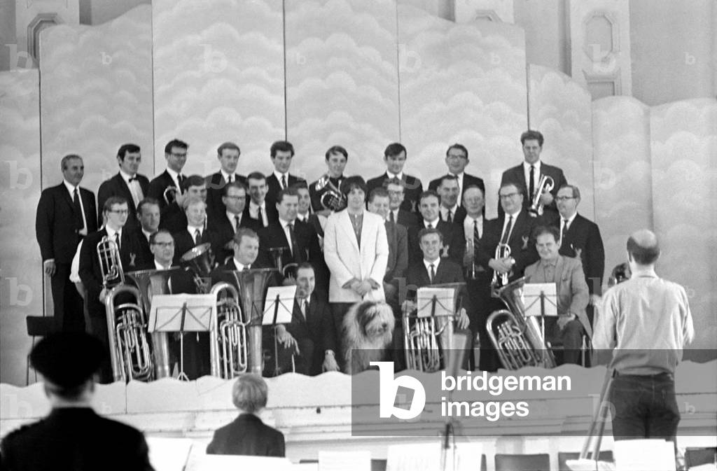 Beatles singer Paul McCartney conducts a brass band, July 1968 (b/w photo)