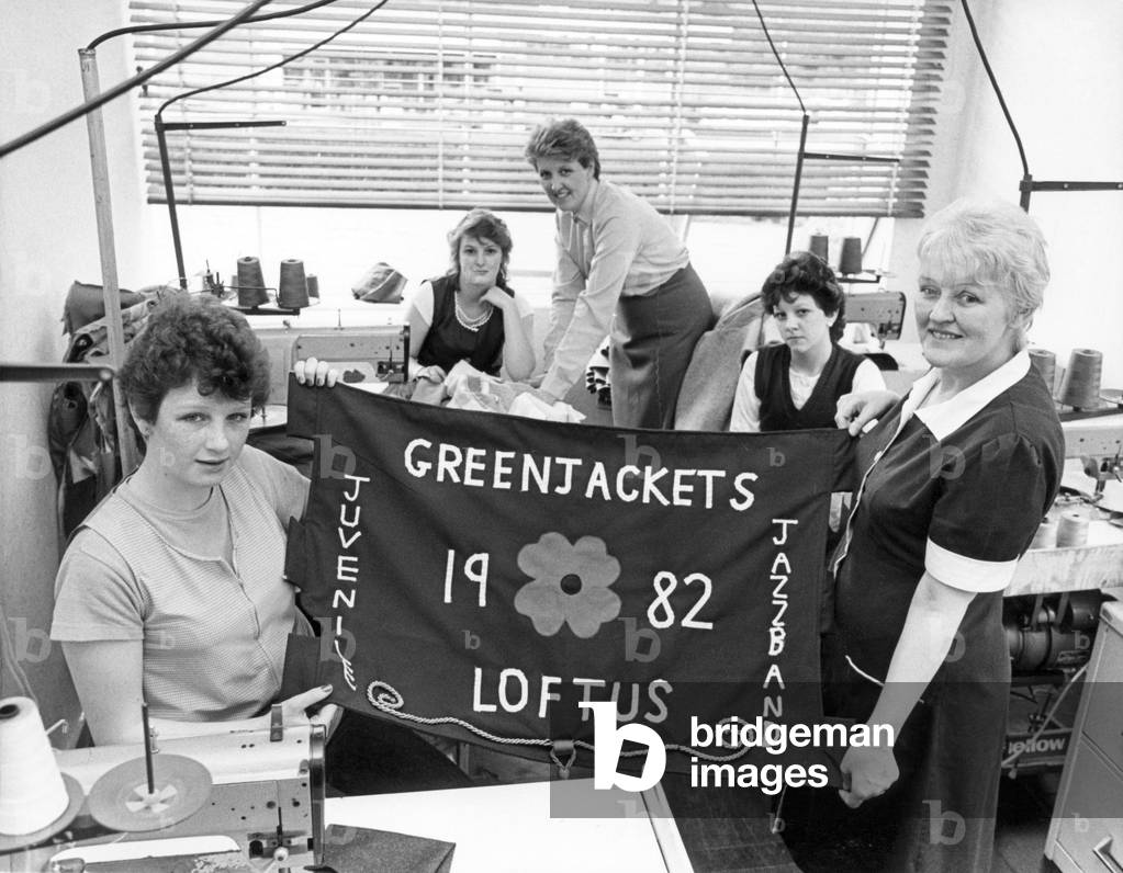 The new Loftus Greenjackets banner is held up by Julie Scaife (left) and Burton's training instructor Lucy Antill. In the background are left are (left to right) Sharon Hick, Barbara Jacobs, personnel and training officer, Deborah Hesk. Circa 1982 (b/w photo)