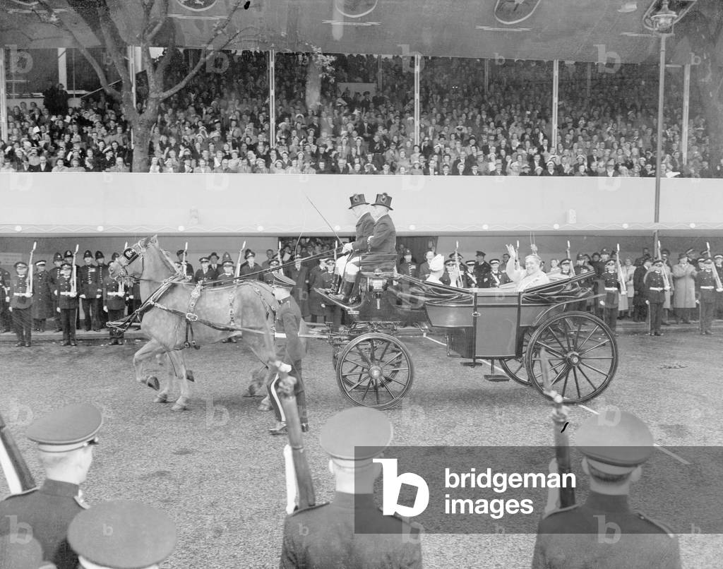 The Coronation of Queen Elizabeth II. Queen Salote of Tonga endearing herself to the cheering crowds by riding through the Parliament Square, London in an open carriage, during the coach ride to Westminster Abbey for the ceremony, smiling and waving, in the pouring rain. 2nd June 1953 (b/w photo)