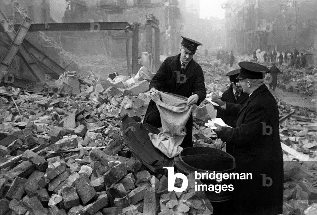 Postmen shift through the wreckage of their central London sorting office looking for letters that survived the blitz, September 1940 (b/w photo)