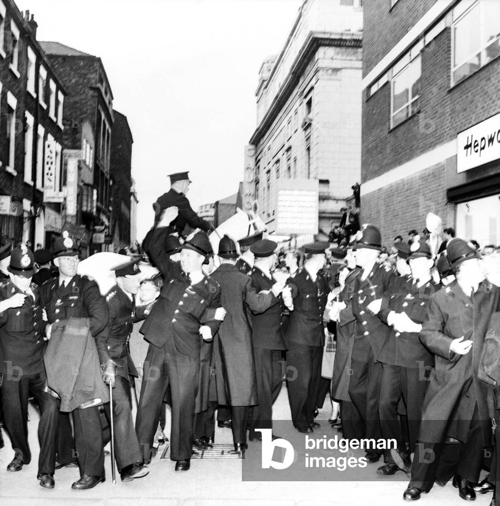 Police try to control fans in the streets of Liverpool before the premiere of the Beatles film 'A Hard Day's Night'. 
July 1964