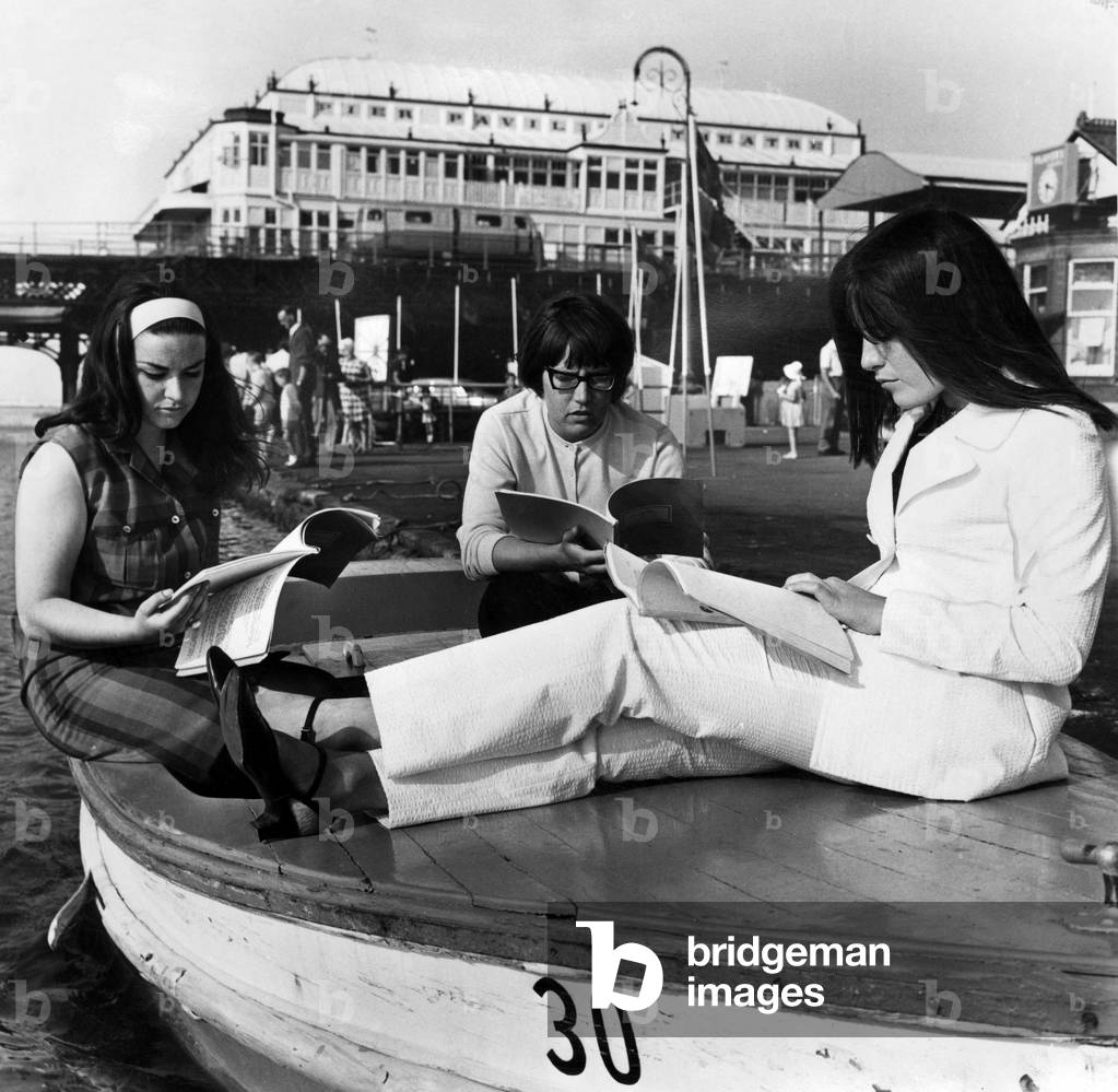 Taking advantage of the warm weather , three of the cast of the Victoria Theatre Company go afloat to scan their scripts (left to right) Sandra Griffin, Diane Langford and Patricia Fuller. 1st July 1966 (b/w photo)