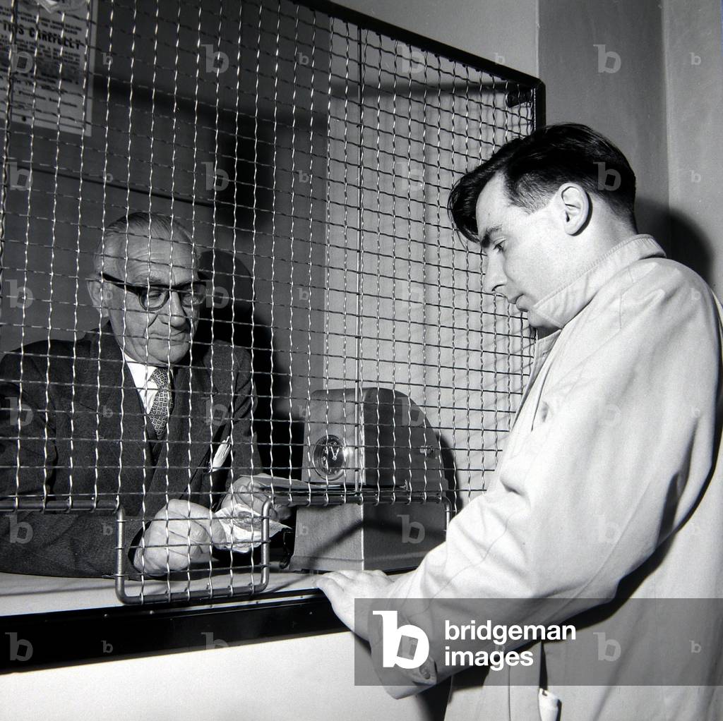 A punter placing a bet at William Massey betting shop in Bethnal Green, London
May 1961