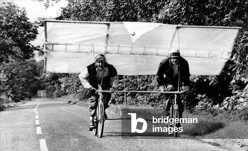 Deep in the heart of Northumberland the 'Whisky Bottle MK.1' emerged on an unsuspecting world. Out of a hangar that doubles as a hayshed, onto the tarmacadam test runway - the road which skirts Bolam Lake, this prototype was jokingly hailed as a revolutionary concept in aviation. Its designers and builders, Daniel Whaley and Roland Johnson, don crash helmets for a 'test flight' , 09/08/1973 (b/w photo)