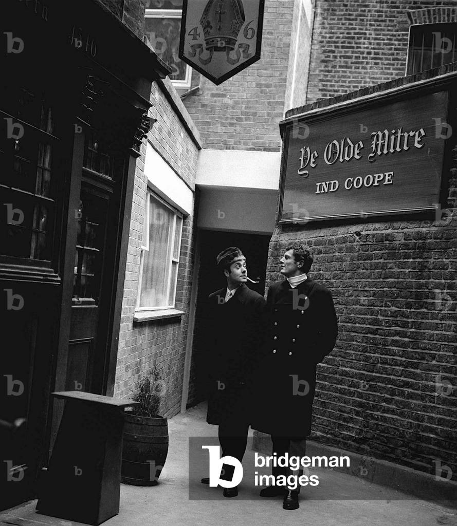 Actor Victor Spinetti models Dr Chicago style coat at a price of £12.00 (Twelve) with fellow model Richard Asman, November 1966 (b/w photo)