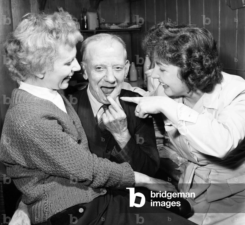 Pensioner with a new tooth. 77 year old man (George Berry) shows off his new tooth, July 1958 (b/w photo)