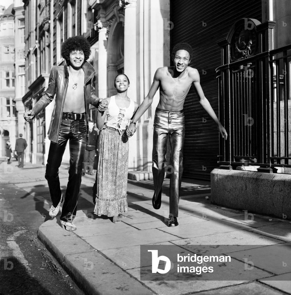 Black teenage boys and girls wearing fashion during a photo shoot.