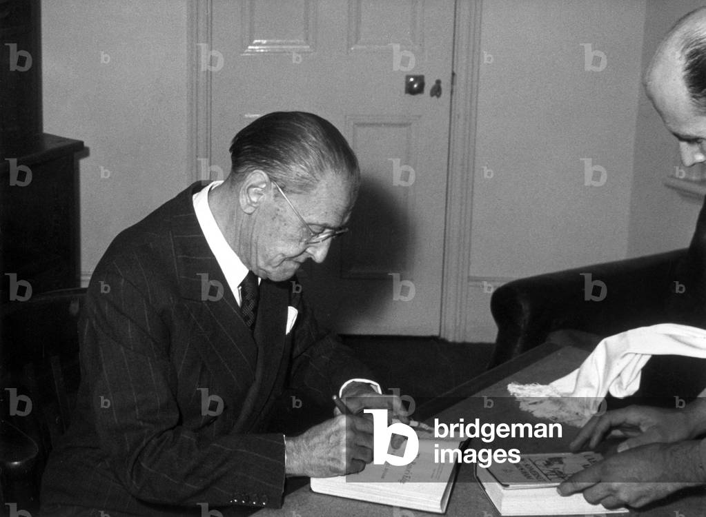 Somerset Maugham signs a copy of his book after his lecture on 