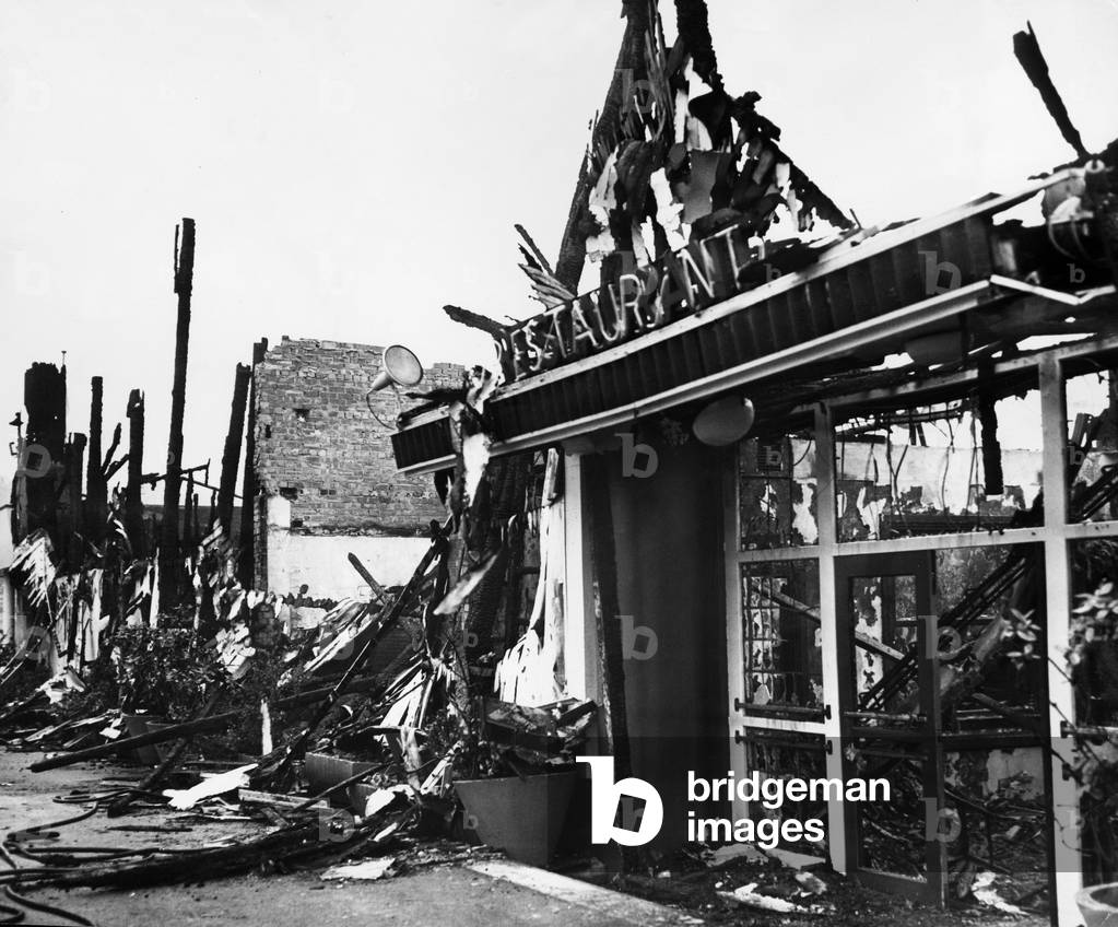 Tangled metal and charred woodwork mark what was once the entrance to the Cumberland and Windermere Suites at Belle Vue, Manchester following the break out of a fire in the park in October 1964 (b/w photo)
