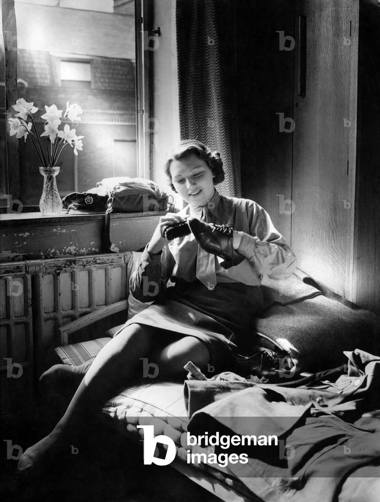 World War II Women. A member of the A.T.S. Shines her shoes before Parade. September 1944