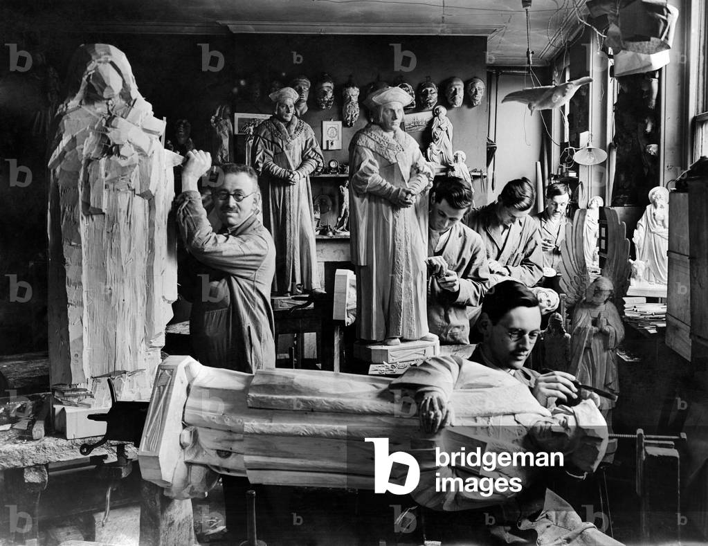 Family of wood carvers seen here with carvings of saints and angels. The studio stands in the shadow of the dome of St Paul's cathedral. March 1935