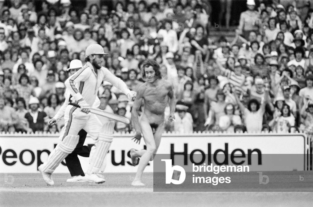 Australian cricket captain Greg Chappell chases a streaker with his cricket bat during a one-day cricket game between Australia and West Indies in Brisbane. 10th December 1979 (b/w photo)