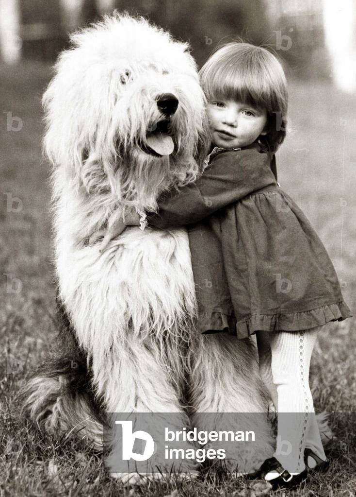 A little girl hugs her canine companion, 22nd January 1962 (b/w photo)