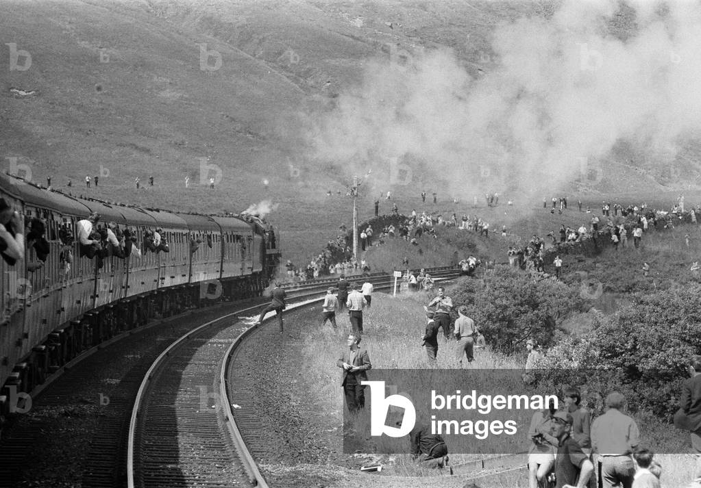 Well-wishers and enthusiasts line the route of BR's last train, even in the remote Pennines, as No. 70013 Oliver Cromwell pounds up the Settle & Carlisle Railway with the 