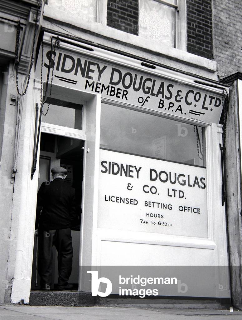 An exterior view of Sidney Douglas betting shop in Mile End Road London
May 1961