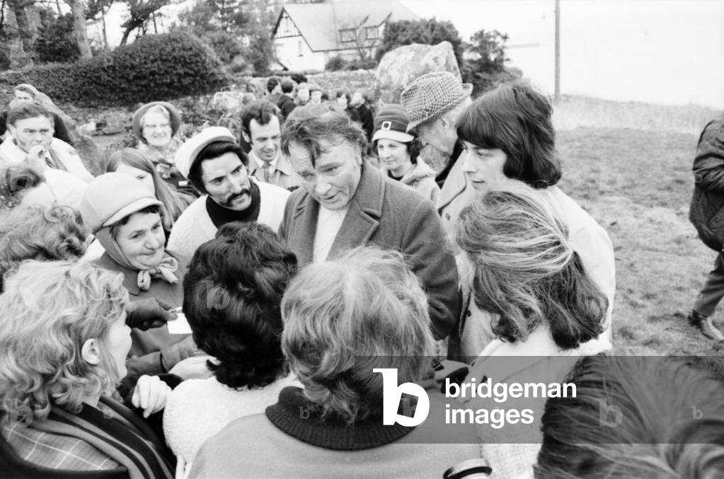 The locations for the film 'Under Milk Wood', depict the Welsh village of Llaregub, So there in the village of Bugerall, Richard Burton contemplates the scene. Fishguard is the location for this fictional Welsh village. Richard Burton meets the rush of housewives during a break in shooting, when they shake hands with 'Boyo', a Welsh expression for Big Boy, as the great Richard, a 'local' lad, came back home. February 1971 (b/w photo)