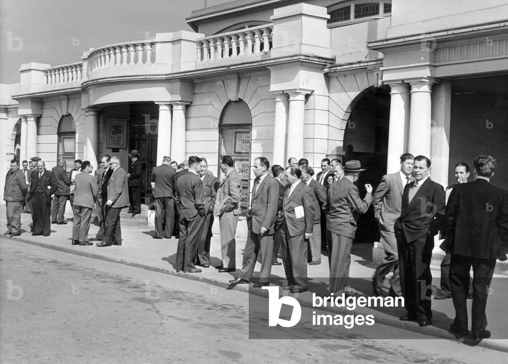 Miners wait outside of the Pavilion at Porthcawl, for the annual NUM South Wales miners conference, Porthcawl, Bridgend, South Wales, 1st May 1962 (b/w photo)