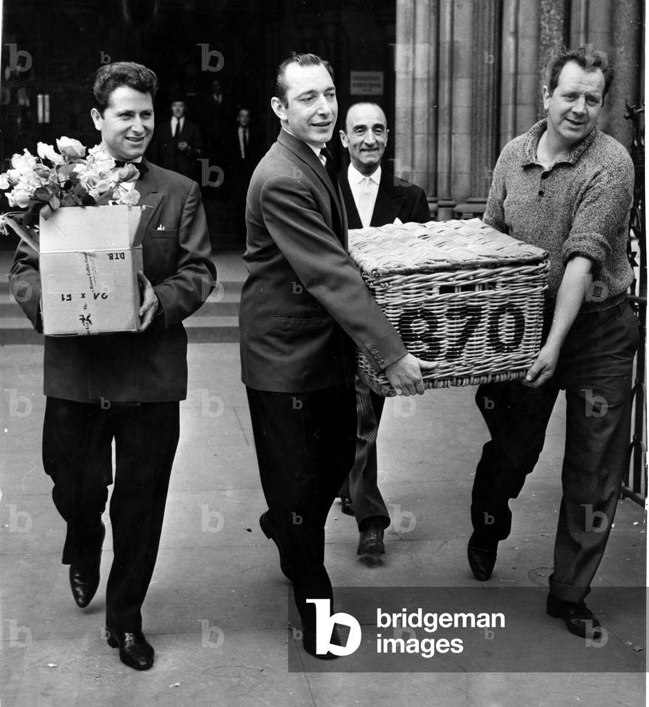 Restaurant men from the Caprice on their way to the Law Courts to serve lunch to millionaire Nubar Gulbenkian. The 66 year old millionaire is embroiled in a lawsuit against the BBC over the 