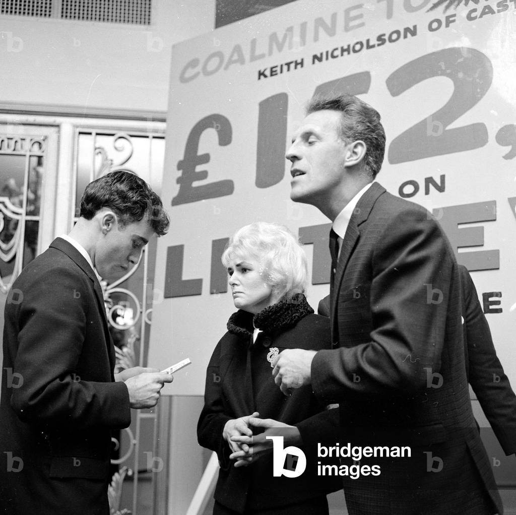Pools winner Vivienne Nicholson and husband Keith Howard Nicholson receive a cheque for £152,000 from television personality Bruce Forsyth after their recent win, September 1961 (b/w photo)