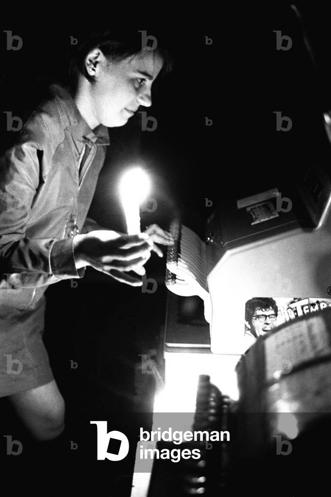 A shop assistant in Newcastle works by candlelight during the power cuts, 07/01/1970