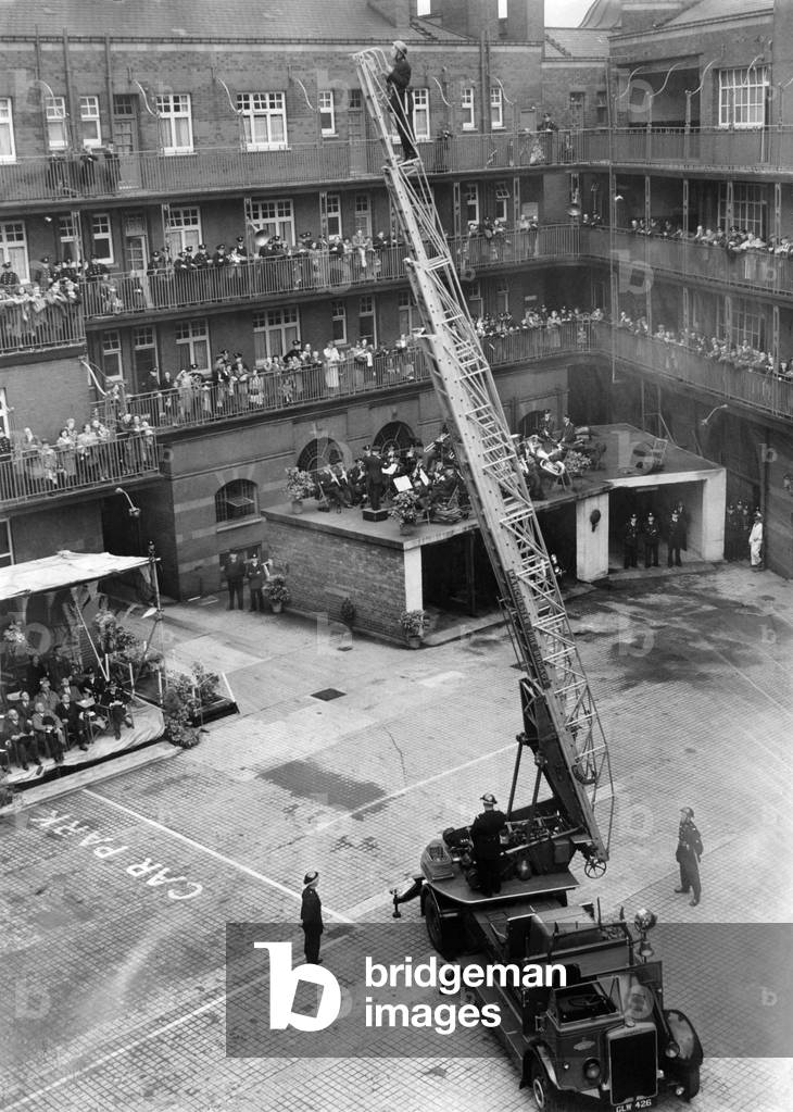 The Manchester Fire Brigade was on Inspection when home office inspectors watched the men at work. General veiw shows the turntable ladder extended with the watchers in the background.
July 1949