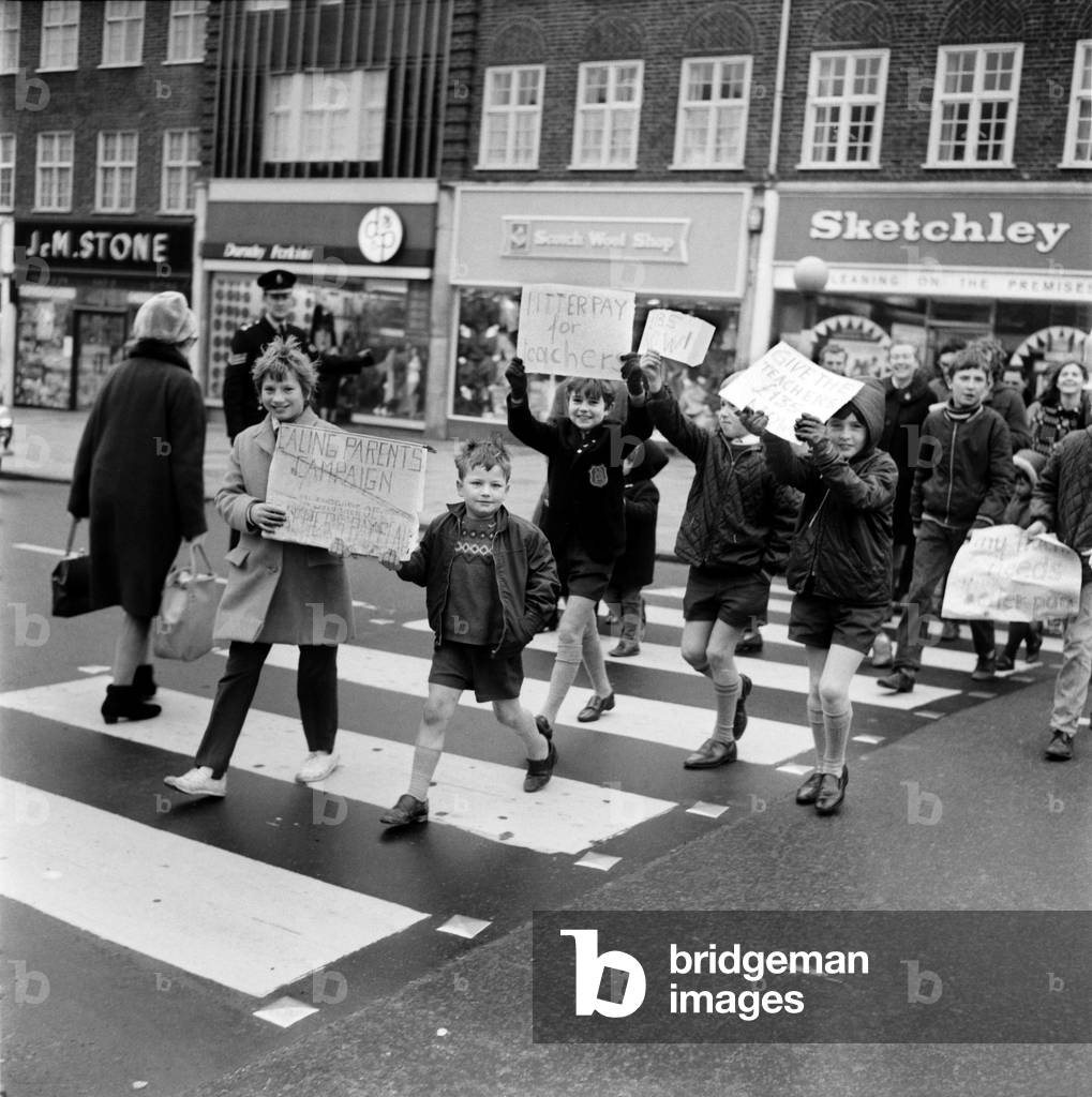 Education. Industrial Disputes: Teachers Strike: All the schools in the Ealing area were closed for the day because of the teachers pay claim dispute. 7 year old Bily Fuller of Stanhope Junior School, Greenford, leads the demonstration down the Broadway with his sister Ann (12) OC Costain Senior Girls School, Greenford. December 1969