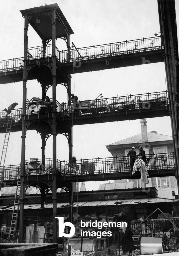 Salvaged beds and bedding being bought out on the verandas at the St. Stephens Hospital Hulham Road, 21st Febuary 1941 (b/w photo)