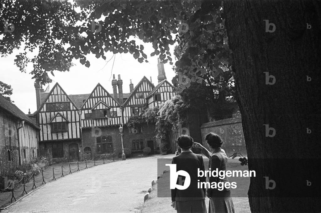 Two women looking at Cheyney's Court in Winchester, c. 1945 (b/w photo)