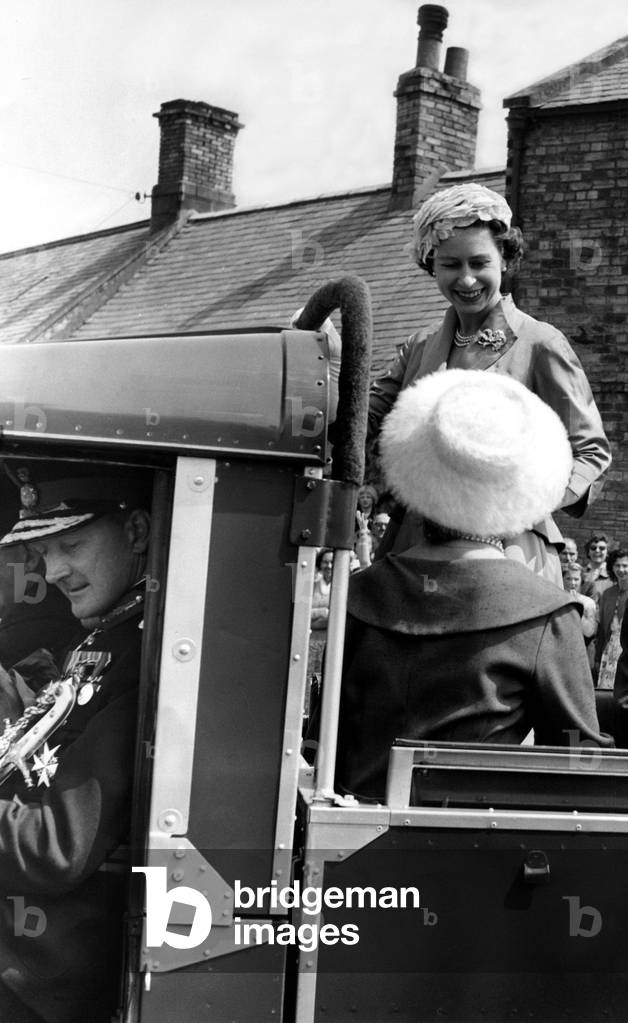 Queen Elizabeth II shares a joke with the Duchess of Northumberland as they leaves the Market Place for the Castle during a visit to Holy Island, 19/06/1958 (b/w photo)