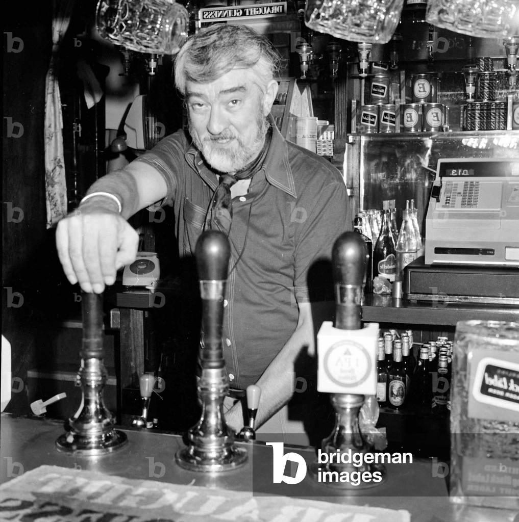 Ivan Beavis, a Coronation Street actor, working as a barman in the Harrow off Fleet Street in London. 1974