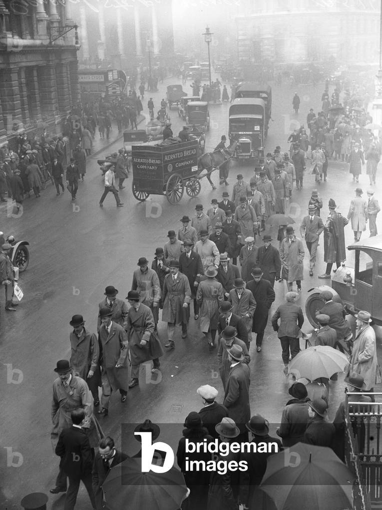 Commuters making their way to work near The Bank in the City of London, on the 8th day of the General Strike. The national dispute came about after negotiations between the miners and mine owners failed over wages and the strike began on 3 May 1926. Millions obeyed the strike call, bringing transport systems to a halt while newspapers were not printed. The government responding by using volunteers to run trains and buses and sent in troops to move supplies from the London docks. There were clashes between police and crowds in many areas and at least 4000 strikers were arrested. There were attacks on buses and trains, including the derailing of the Flying Scotsman. The strike was called off unilaterally by the TUC on 12 May with no guarantees of fair treatment for the miners who fought on to bitter defeat in October. 11th May 1926 (b/w photo)