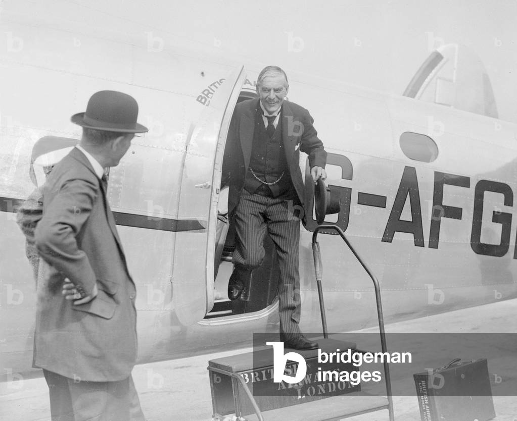 British Prime Minister Neville Chamberlain greeted by Lord Halifax (in bowler hat) on his arrival at Heston airport following one of his meetings with German Chancellor Adolf Hitler in his Berchtesgaden mountain retreat, 16th September 1938 (b/w photo)