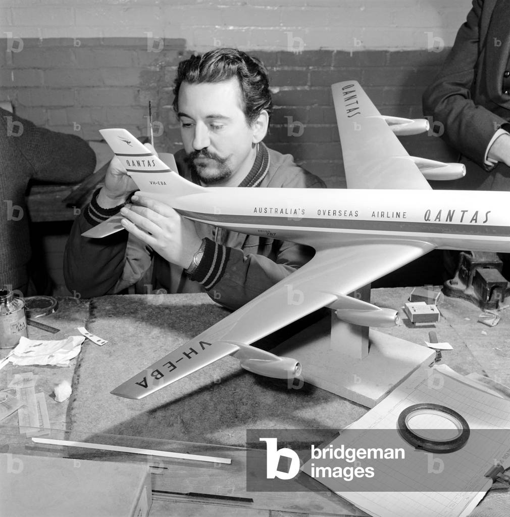 Factory where model aircraft for the travel agents are made. Men making model planes. Model maker painting tailplane of model Circa 1960