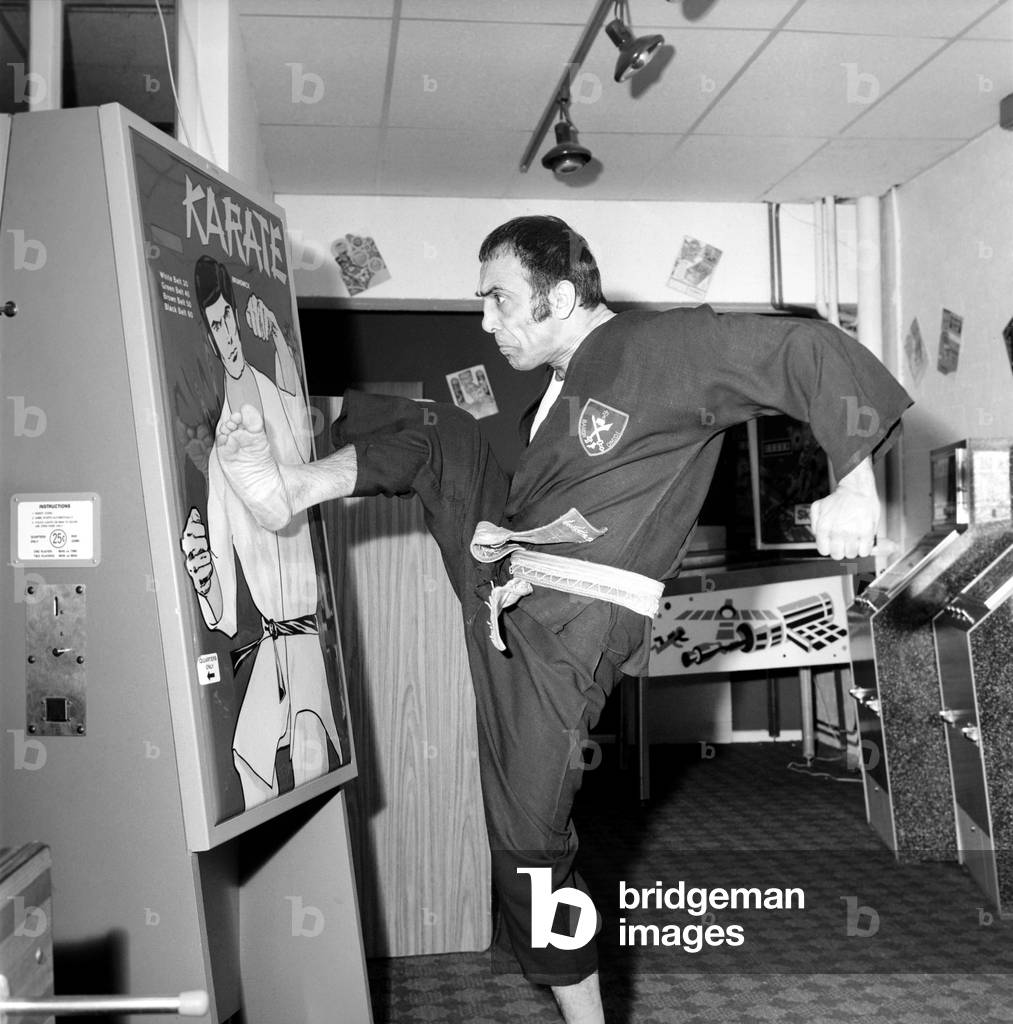 Karate Machine: Man/Machine/Unusual/Humour: Kung Fu man Baron Omidi tries out the new Karate machine at the distributors factory in North West London, February 1975