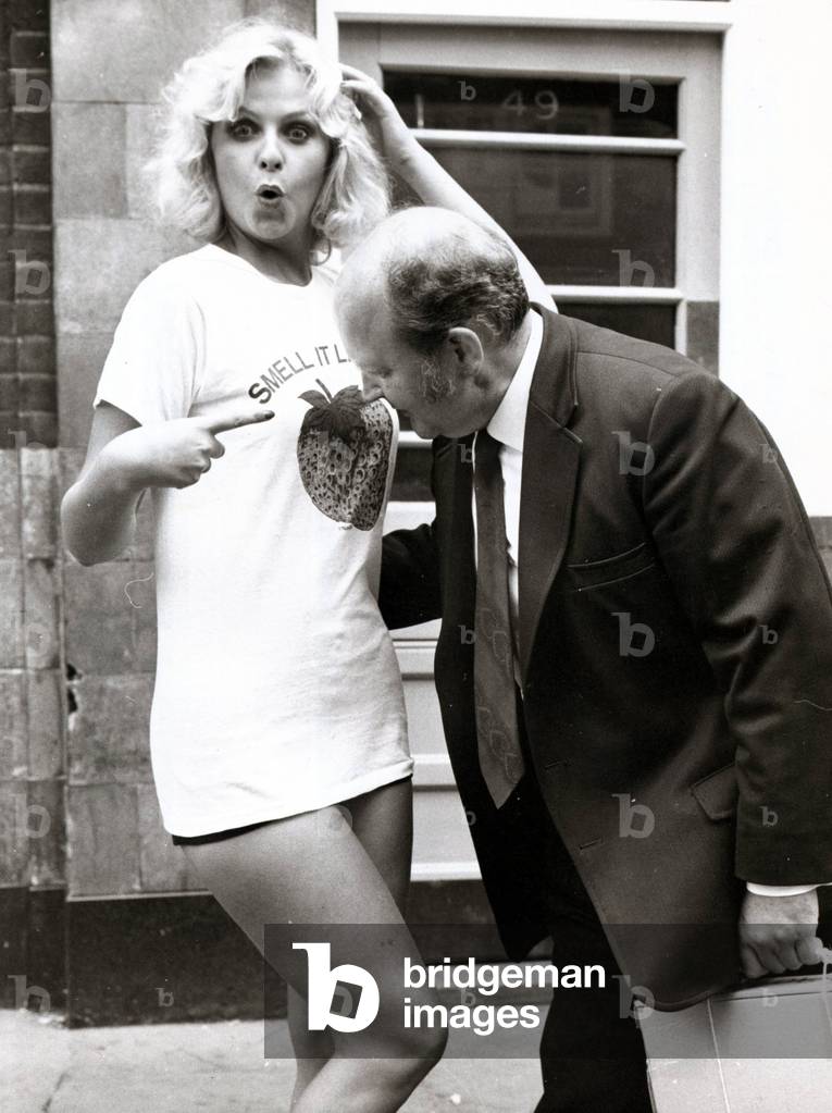 Marie Louis wearing a T Shirt with Strawberry Print as a, Man moves in to have a smell. The t shirts have been designed to give off the scent of fresh fruit and are to go in sale in the USA, October 1974 (b/w photo)