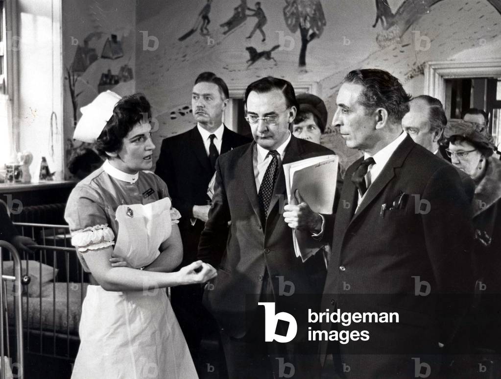 The Secretary of State for Wales, Mr. George Thomas, talks to Deputy Sister Margaret Hicks, in one of the wards at Ely hospital, 1969 (b/w photo)