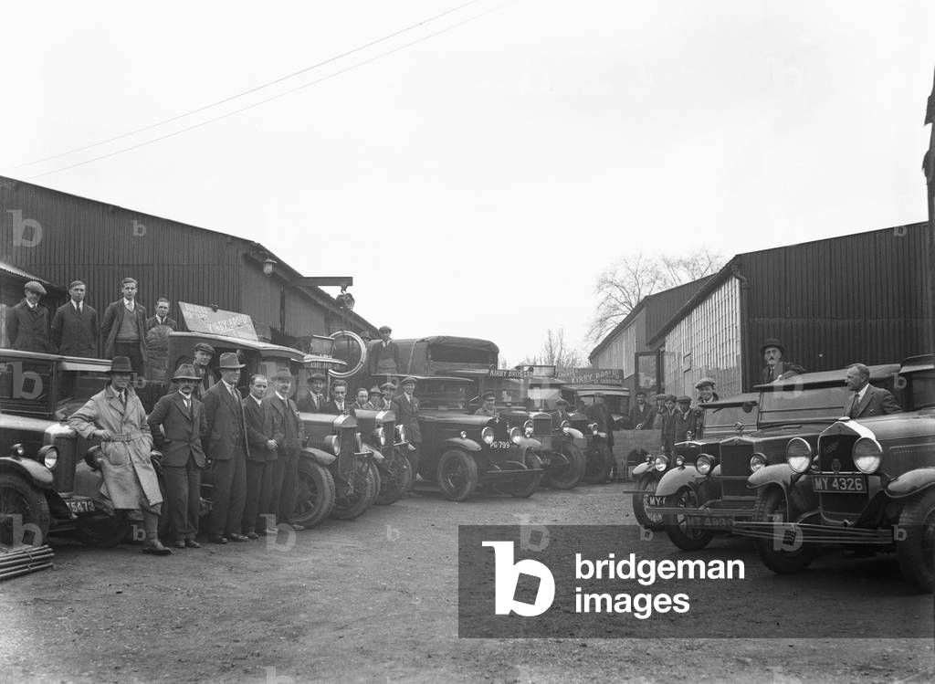 The staff of Uxbridge builders merchants Kirby Brothers pose beside their lorries and vans, London, c. 1930 (b/w photo)