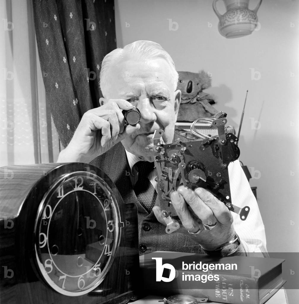 Timelord: Clock repairer Bill Marshall seen here repairing the movement to a mantle clock. 1960