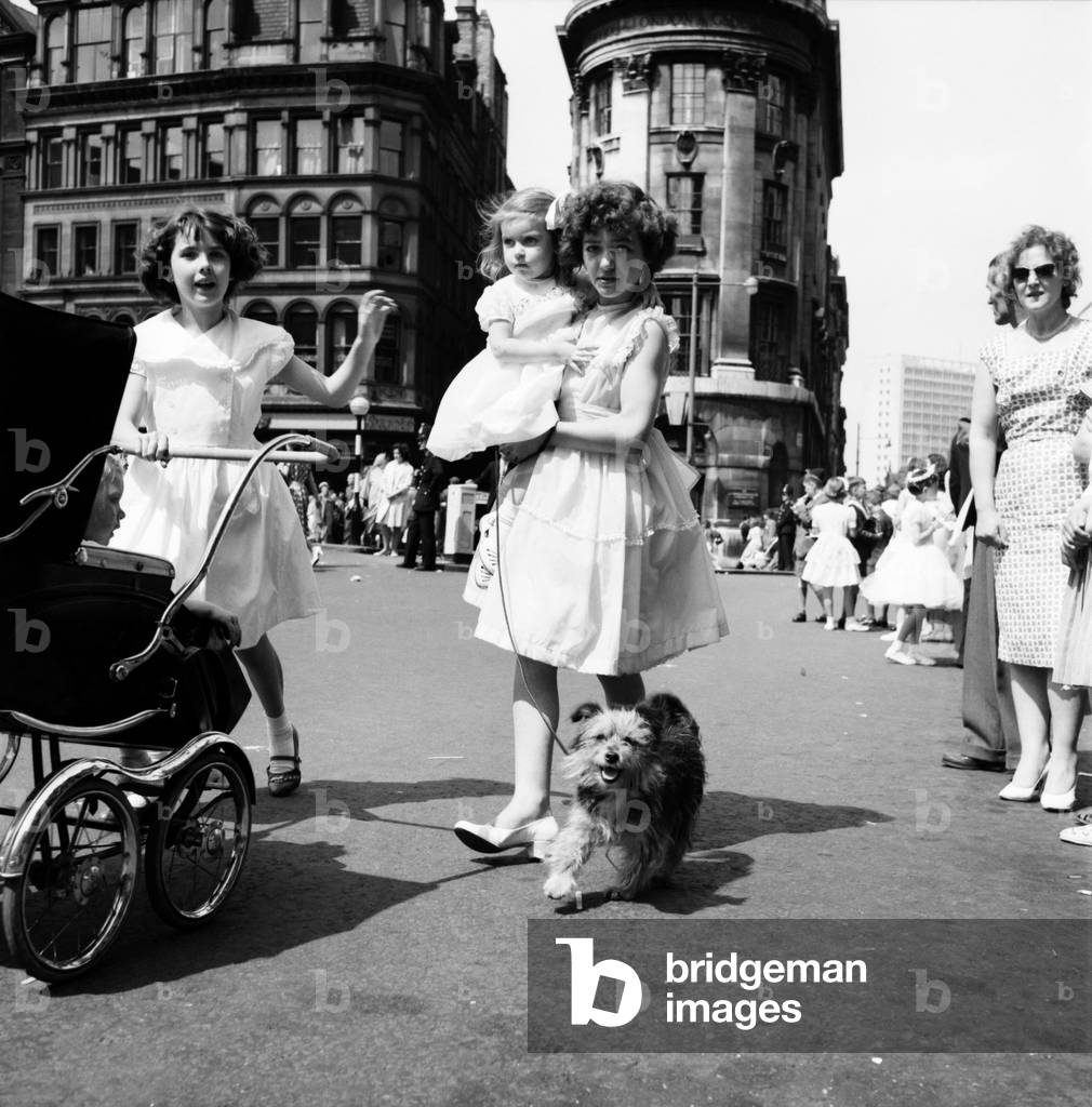 Whit Walks Manchester: The little girl who brought her dog along to walk in the Whit Walks was Diane Pugh aged 3 of Manchester. With her is Anne Grimley aged 11 and, of course, Judy the Yorkshire terrier. June 1960