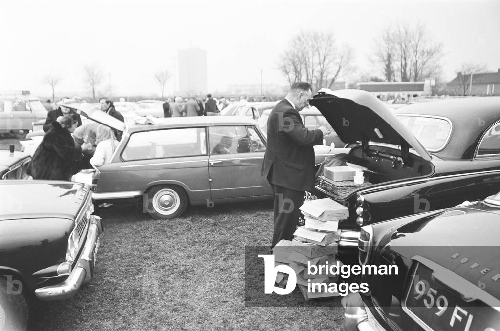 Supporters of Oxford and Cambridge Universities gather in the West Car Park at Twickenham for a traditional picnic lunch before the Varsity rugby match. 8th December 1967 (b/w photo)
