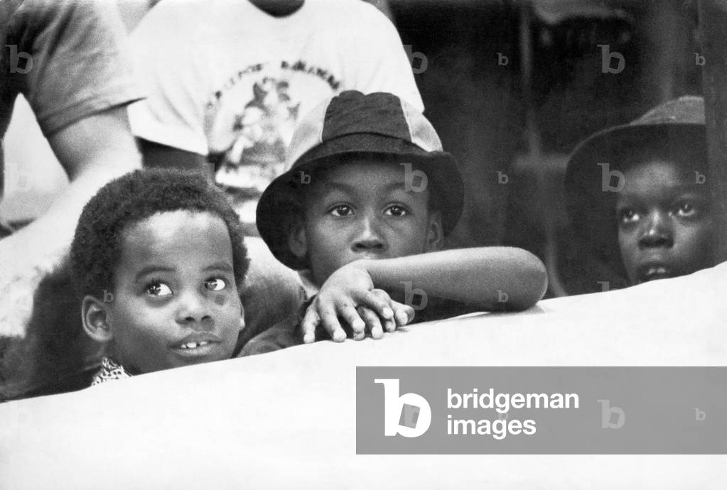 Muhammad Ali (born Cassius Marcellus Clay, Jr.; January, 17, 1942) is an American former professional boxer, generally considered among the greatest heavyweights in the sport's history. A controversial and polarising figure during his early career, Ali is widely regarded for the skills he displayed in the ring plus the values he exemplified outside of it. (Pictures shows) Muhammad Ali's young fan's watching him train from ringside., 1st September 1974 (b/w photo)