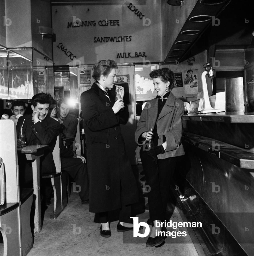Girls meet up with friends at a coffee bar in London's West End. November 1953 (b/w photo)