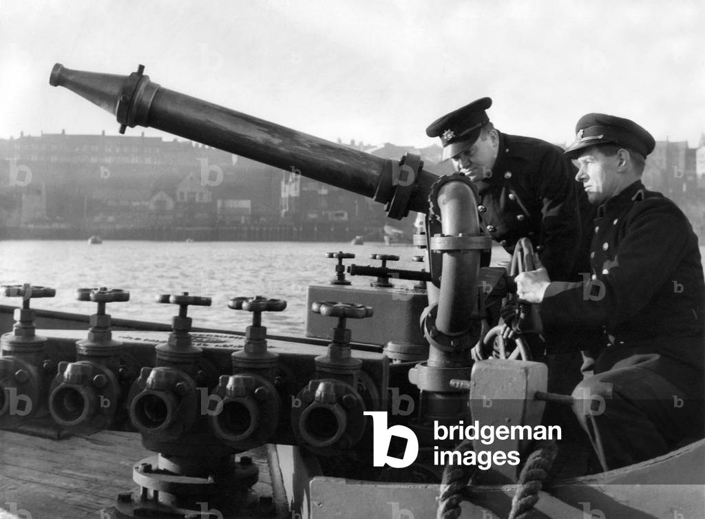 Some of the floating firemen demonstrating the boat's water gun, c.1960