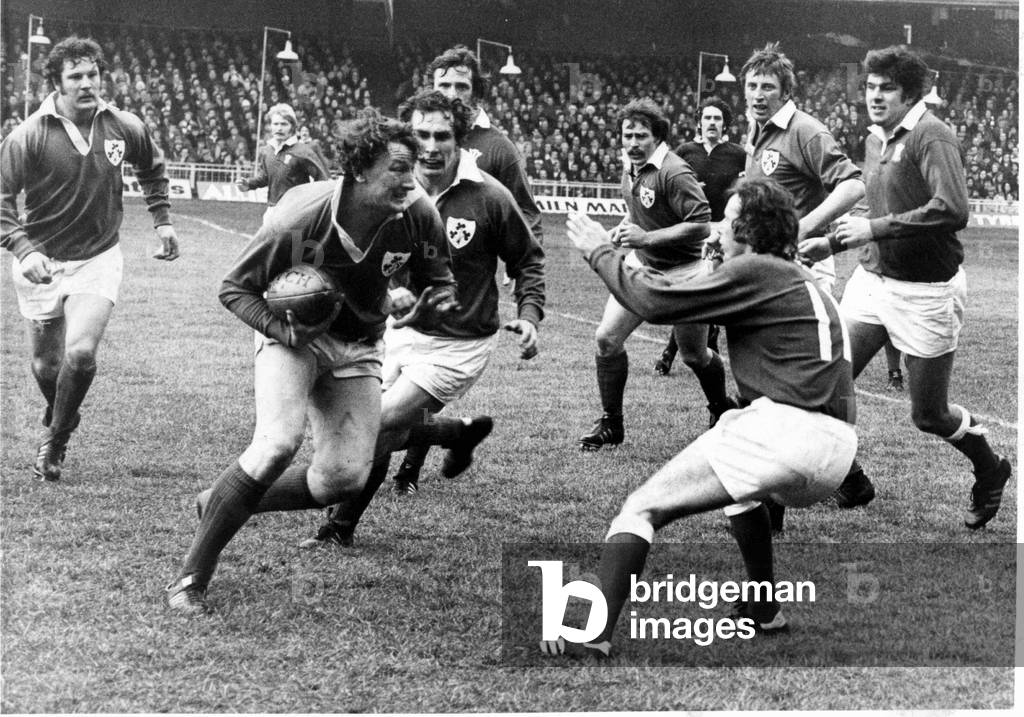 Five Nations match at Cardiff Arms Park. Wales 25 v Ireland 9 Willie Duggan, the Irish No.8, who was later sent off, shapes up to take on the challenge of J J Williams. 15th January 1977 (b/w photo)