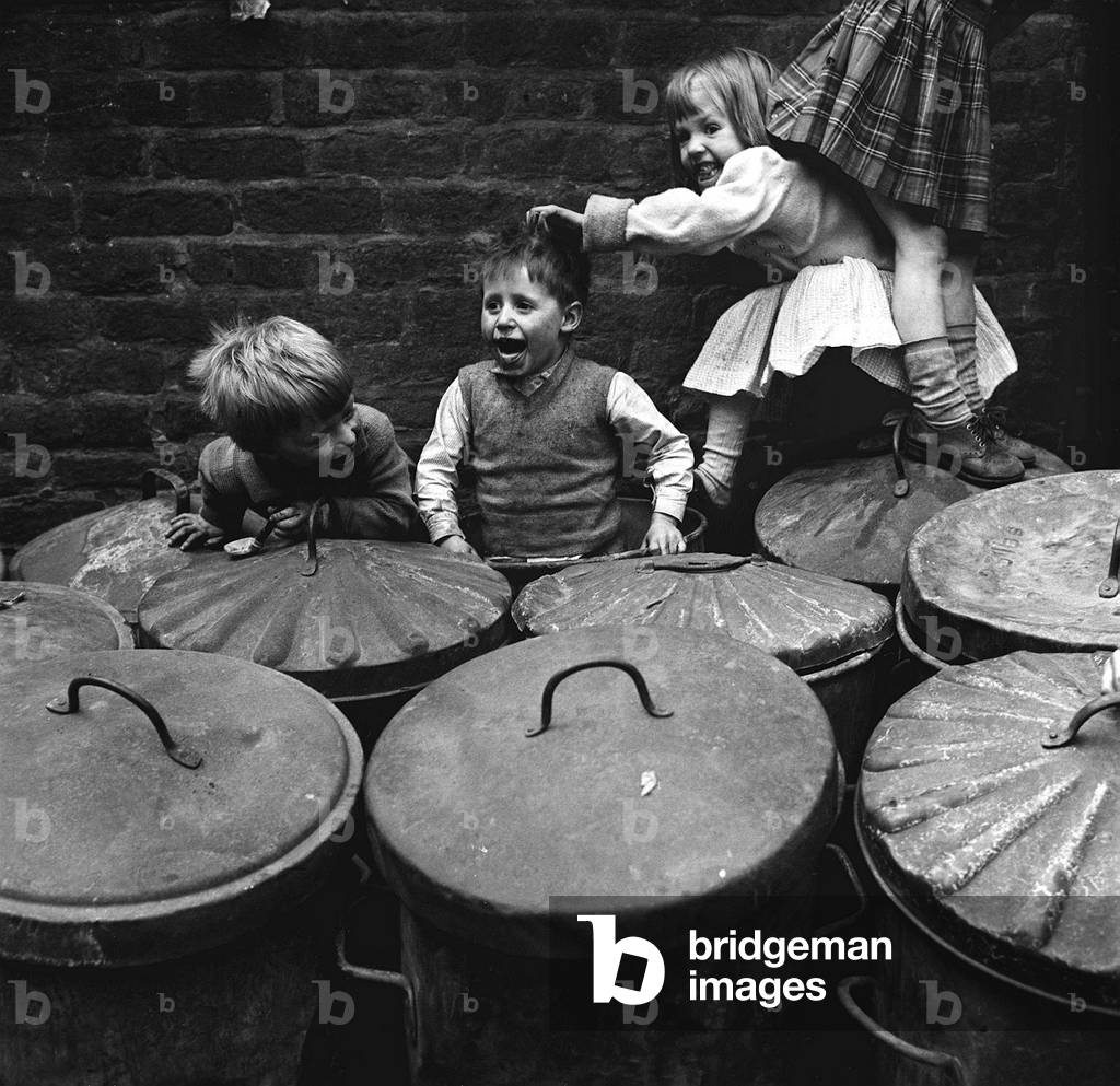 Children playing dustbins on a slum housing estate
01/06/62
