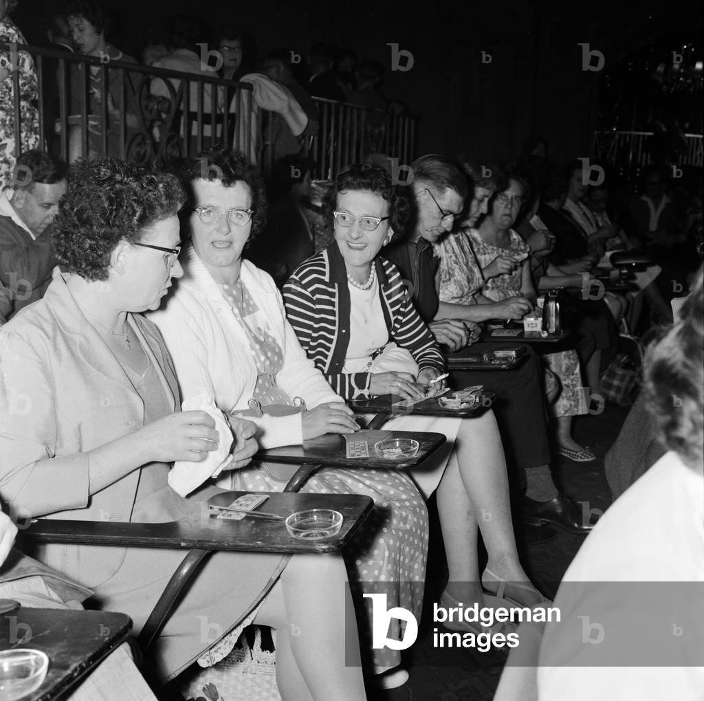 Newsagent Mrs Helen Retter (centre) with other members of her syndicate before they picked up £83 in prize money after a winning night out playing bingo at Maida Vale. 9th August 1961 (b/w photo)